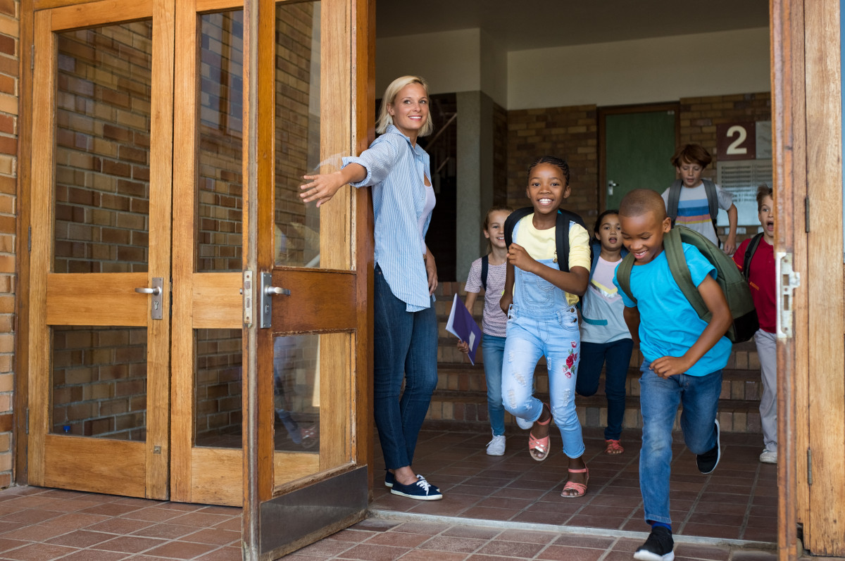 Teacher letting students out of school for summer break.